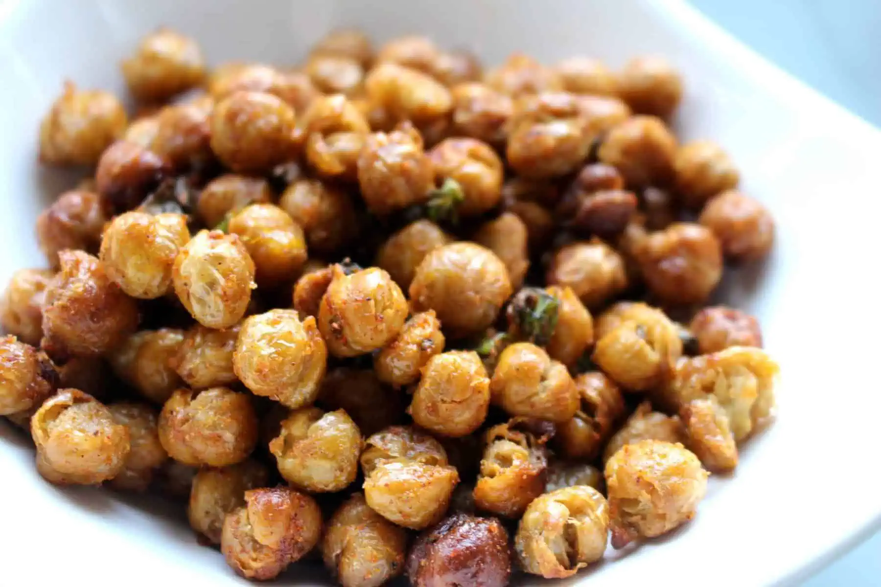 Close up of crispy chickpeas in a white bowl.