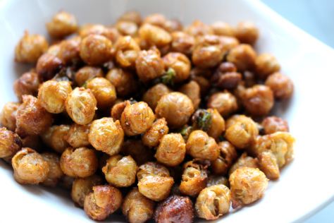 Close up of roasted chick peas in a small white bowl.