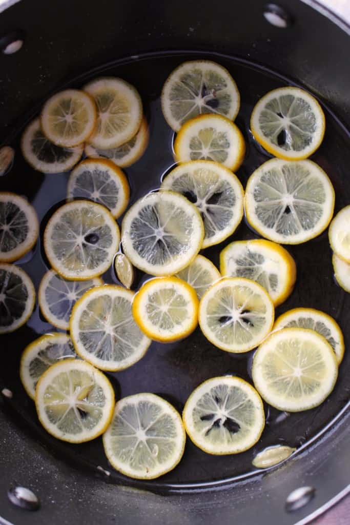Super thin lemon slices in a pan of water.