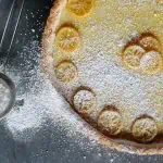Top view of a Meyer lemon tart dusted with powdered sugar.