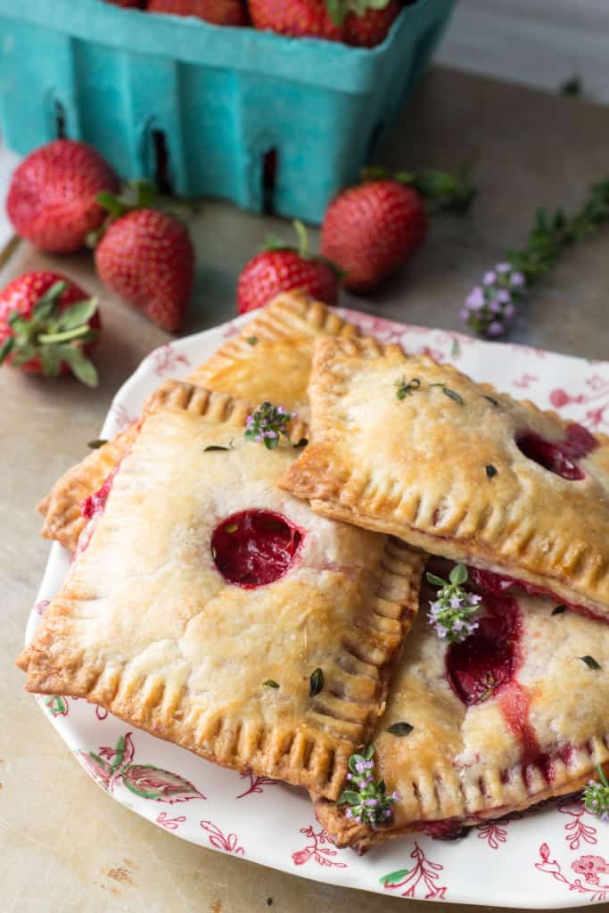 A stack of several strawberry goat cheese pop tarts stacked on a floral plate.