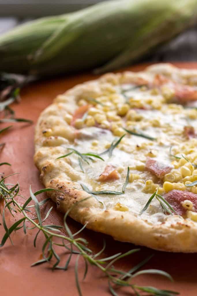 Top view of prosciutto and corn grilled pizza.