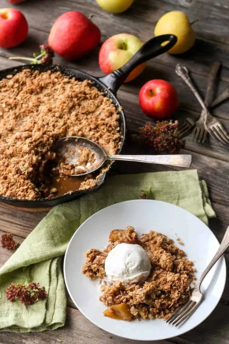 Brown butter apple crisp in a cast iron skillet, and a plated serving.