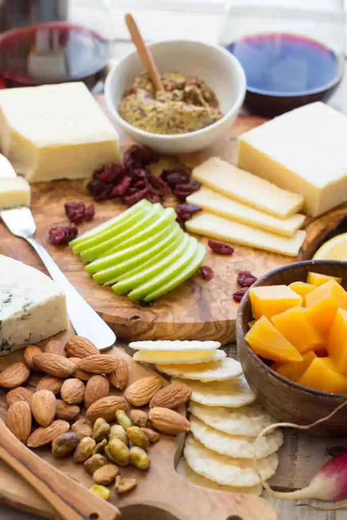 Charcuterie spread of cheese, apples, nuts, and crackers.