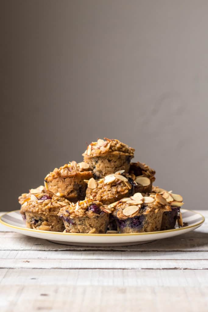 Blueberry almond baked oatmeal cups stacked up on a dinner plate.
