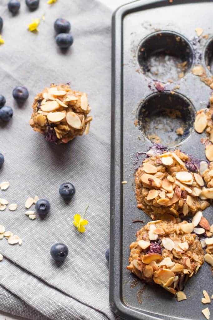 A blueberry oatmeal cup next to a muffin tin.