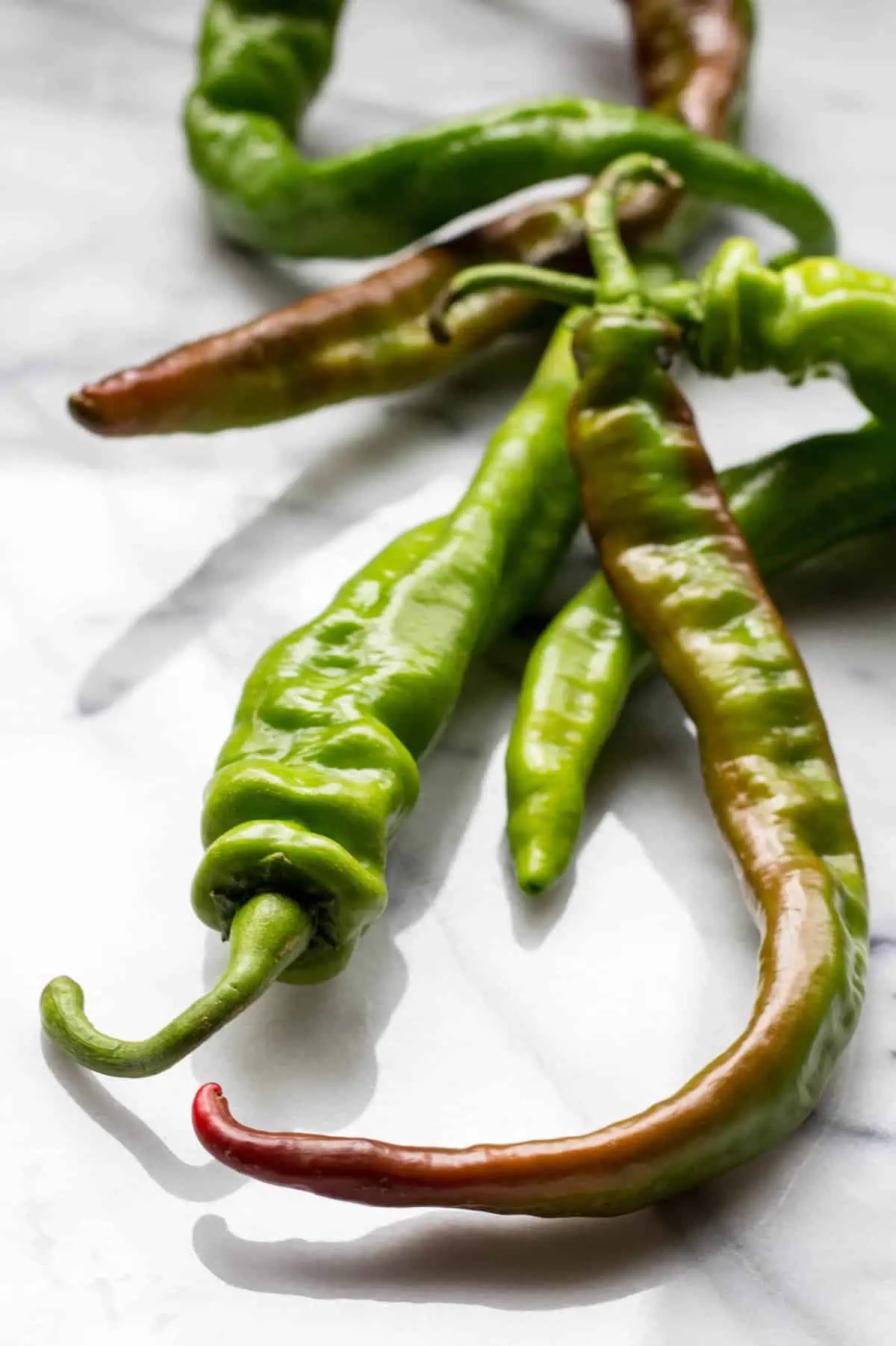 Close up of long hot peppers on a table.