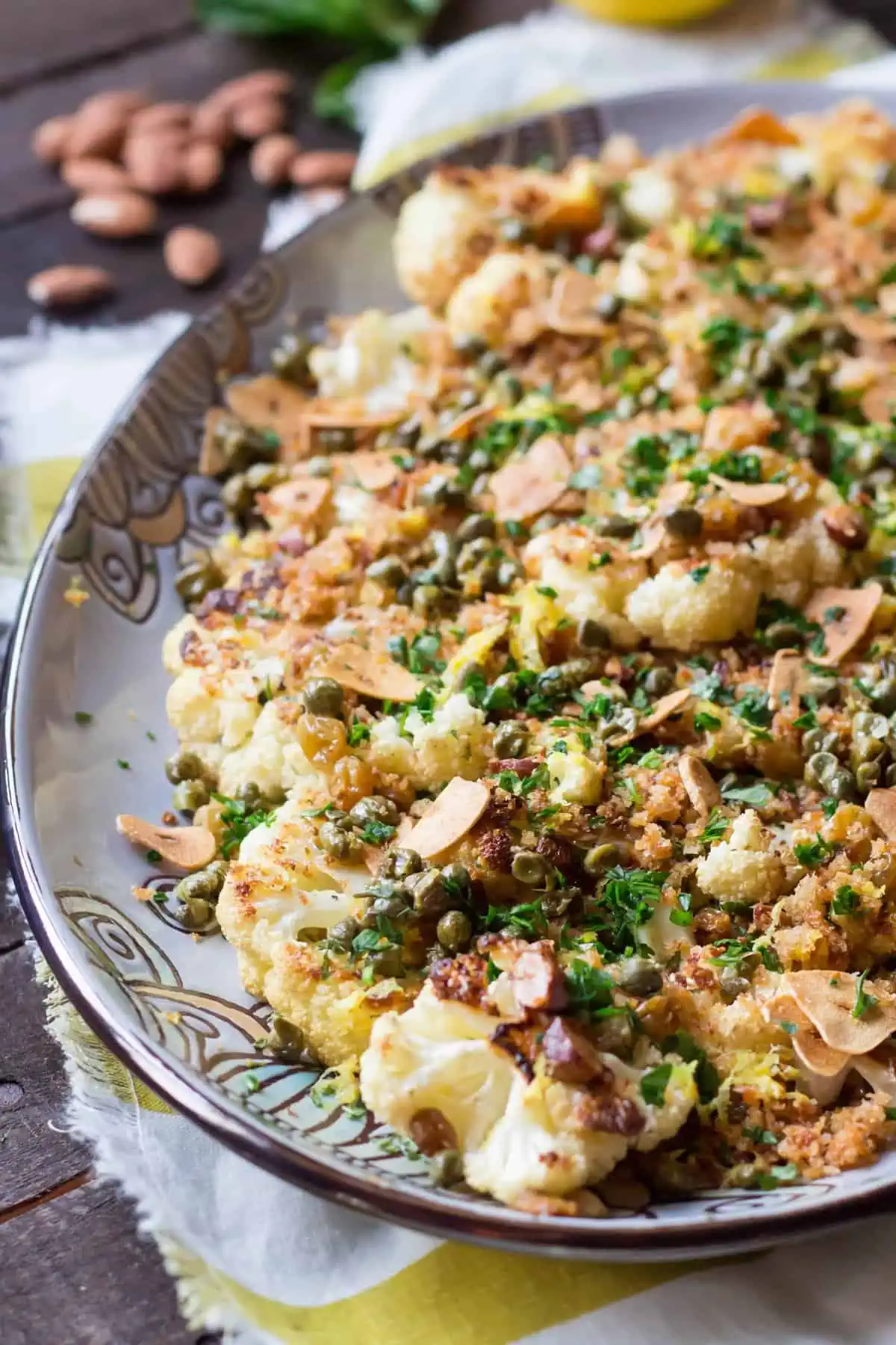 Roasted cauliflower with almonds and capers on an oval serving platter.