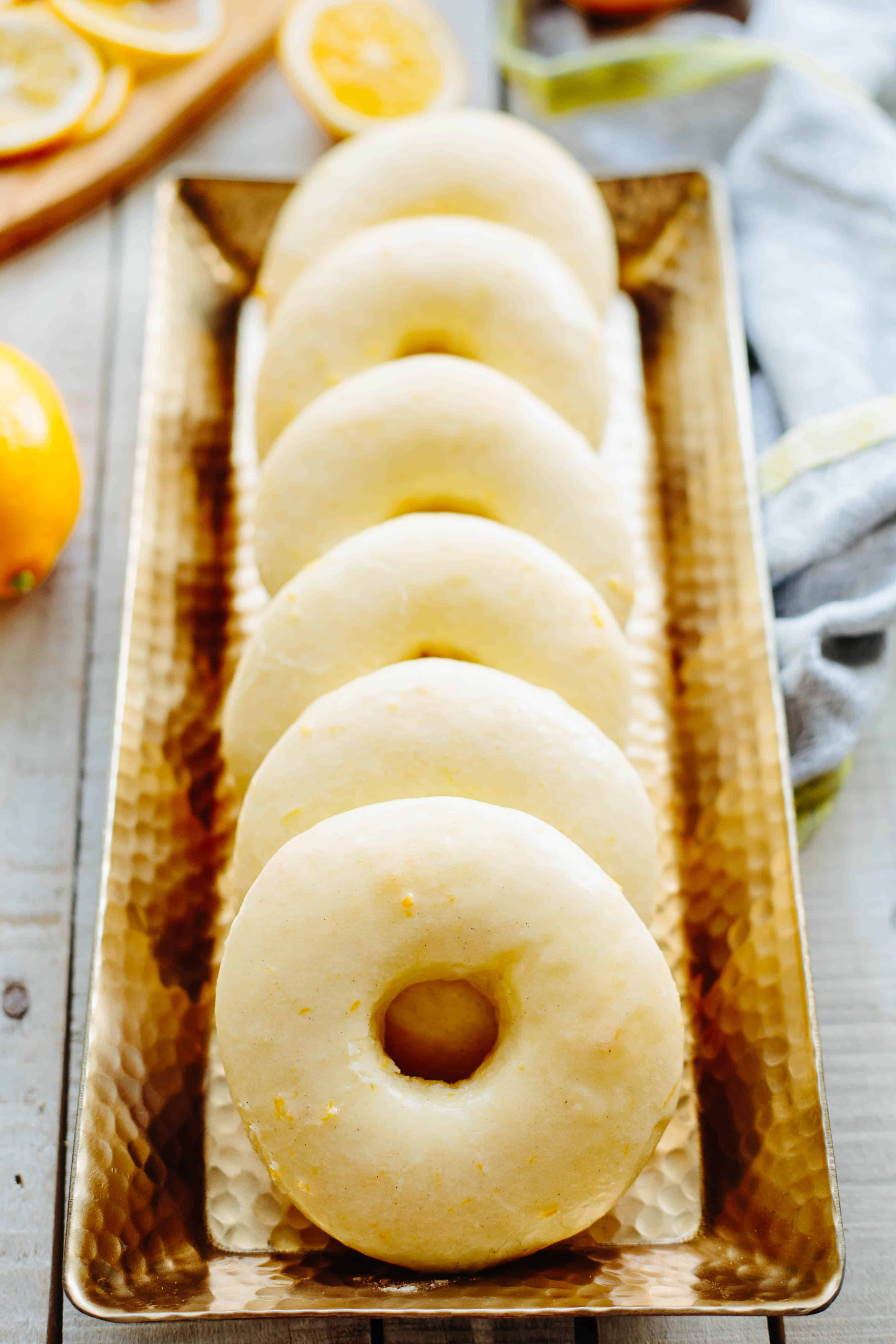 Lemon doughnuts standing on end in a narrow metal tray.