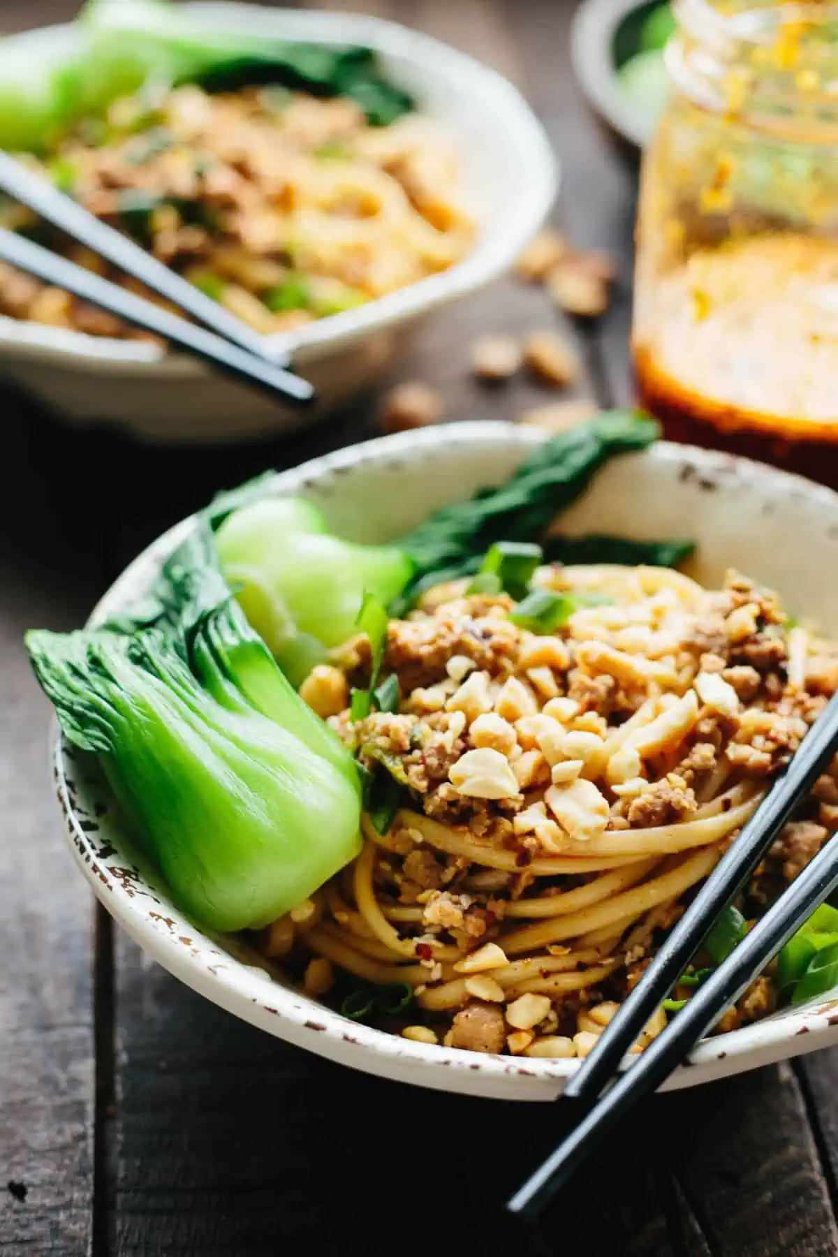 A bowl of baby bok choy and dan dan noodle recipe with chopsticks at the ready.