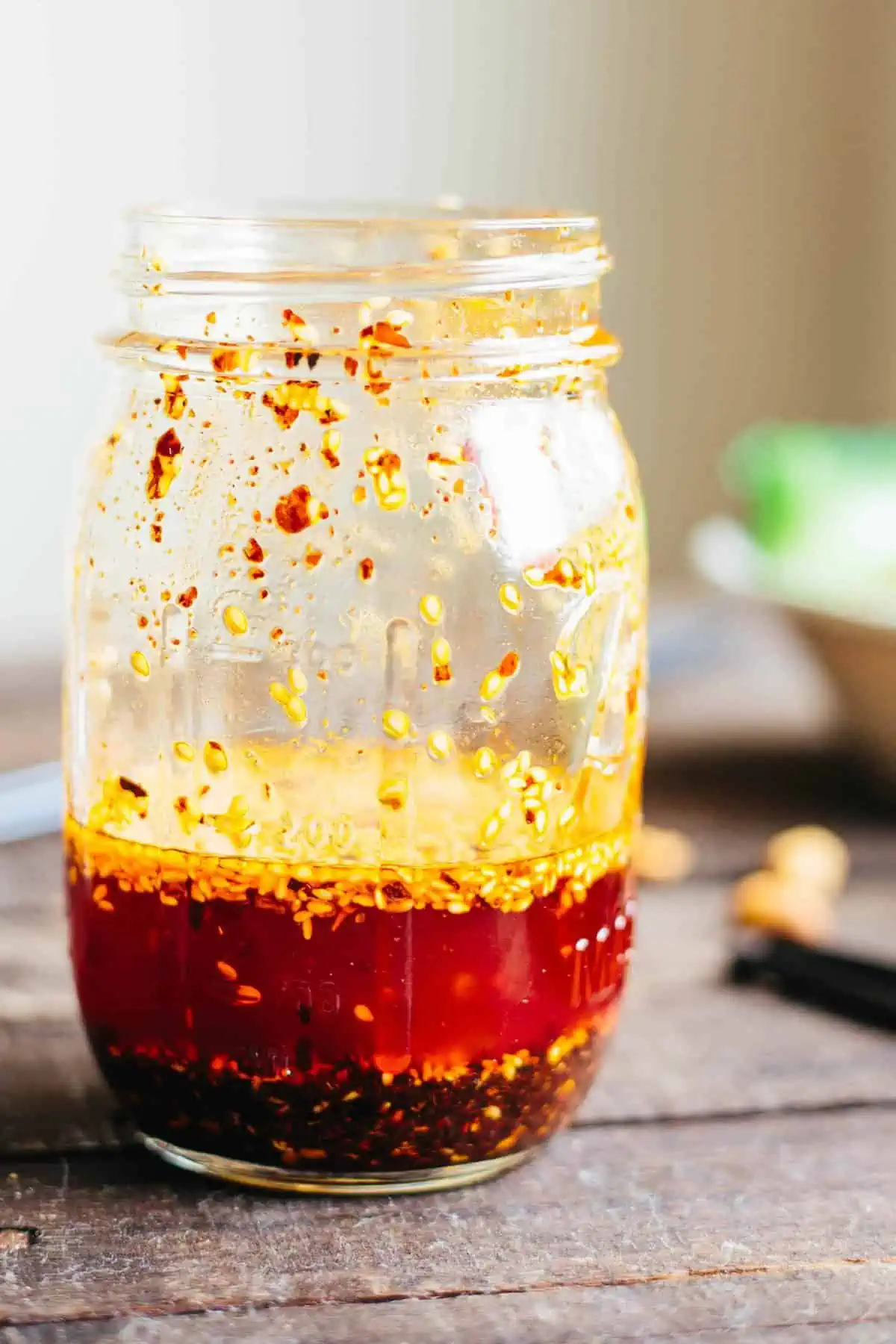 Close up side view of a glass jar of homemade chili oil.