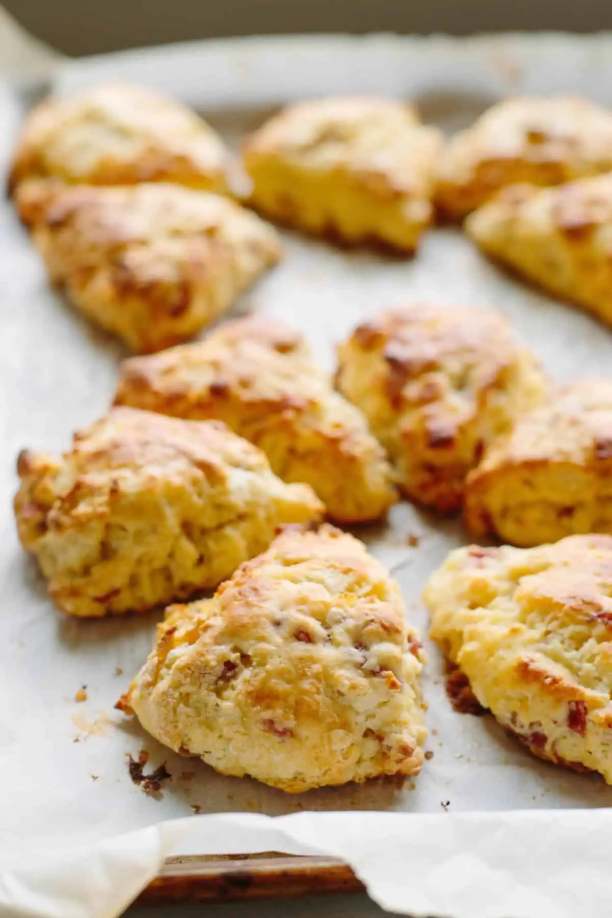 Freshly baked prosciutto goat cheese scones on a baking sheet.