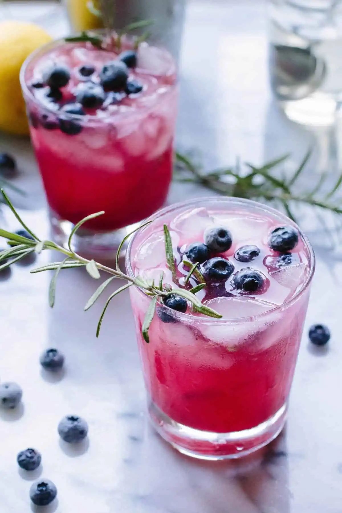 A glass of blueberry rosemary vodka spritzer.