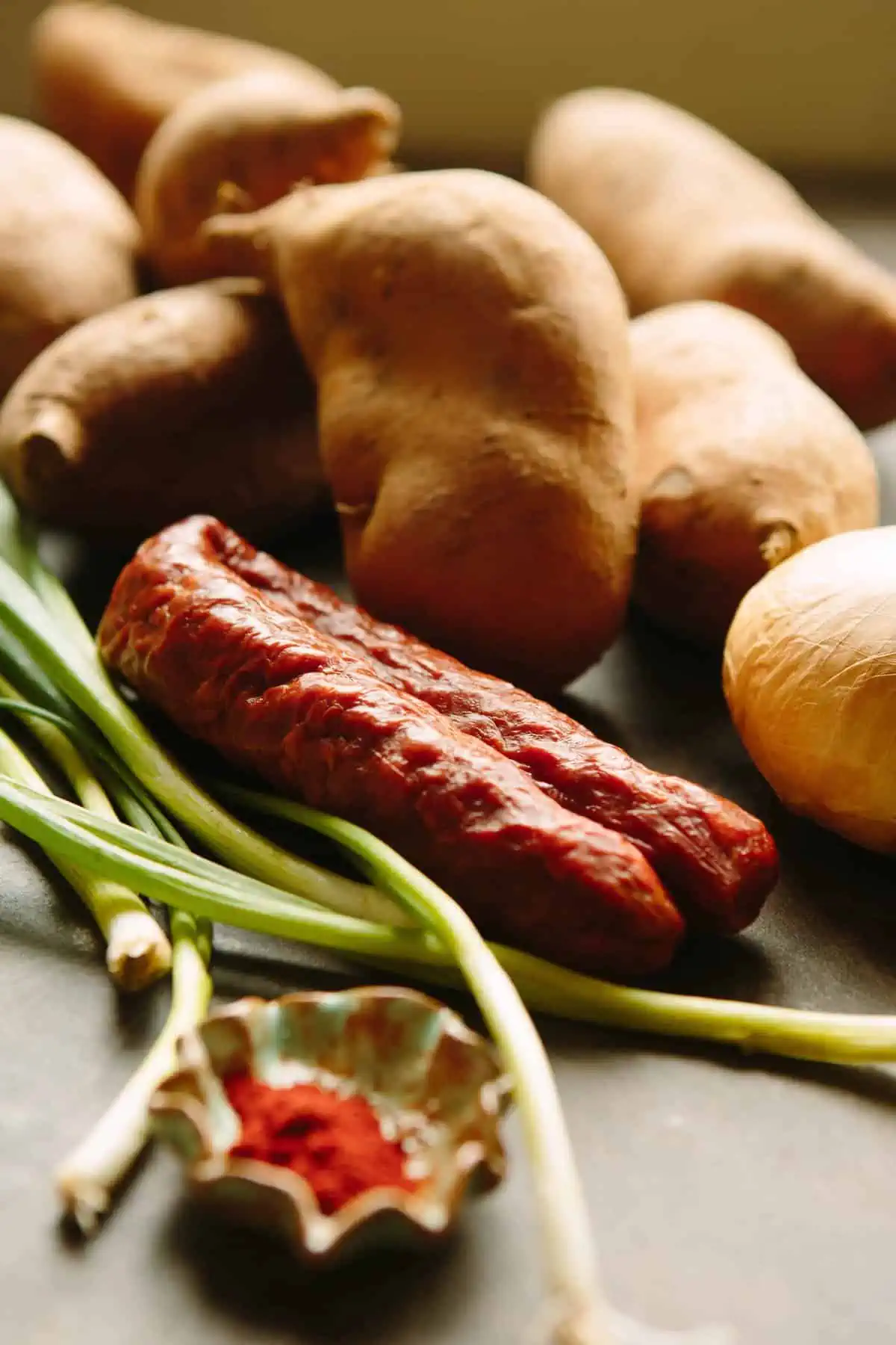 Close up of chorizo sausage, green onions, and russet potatoes.