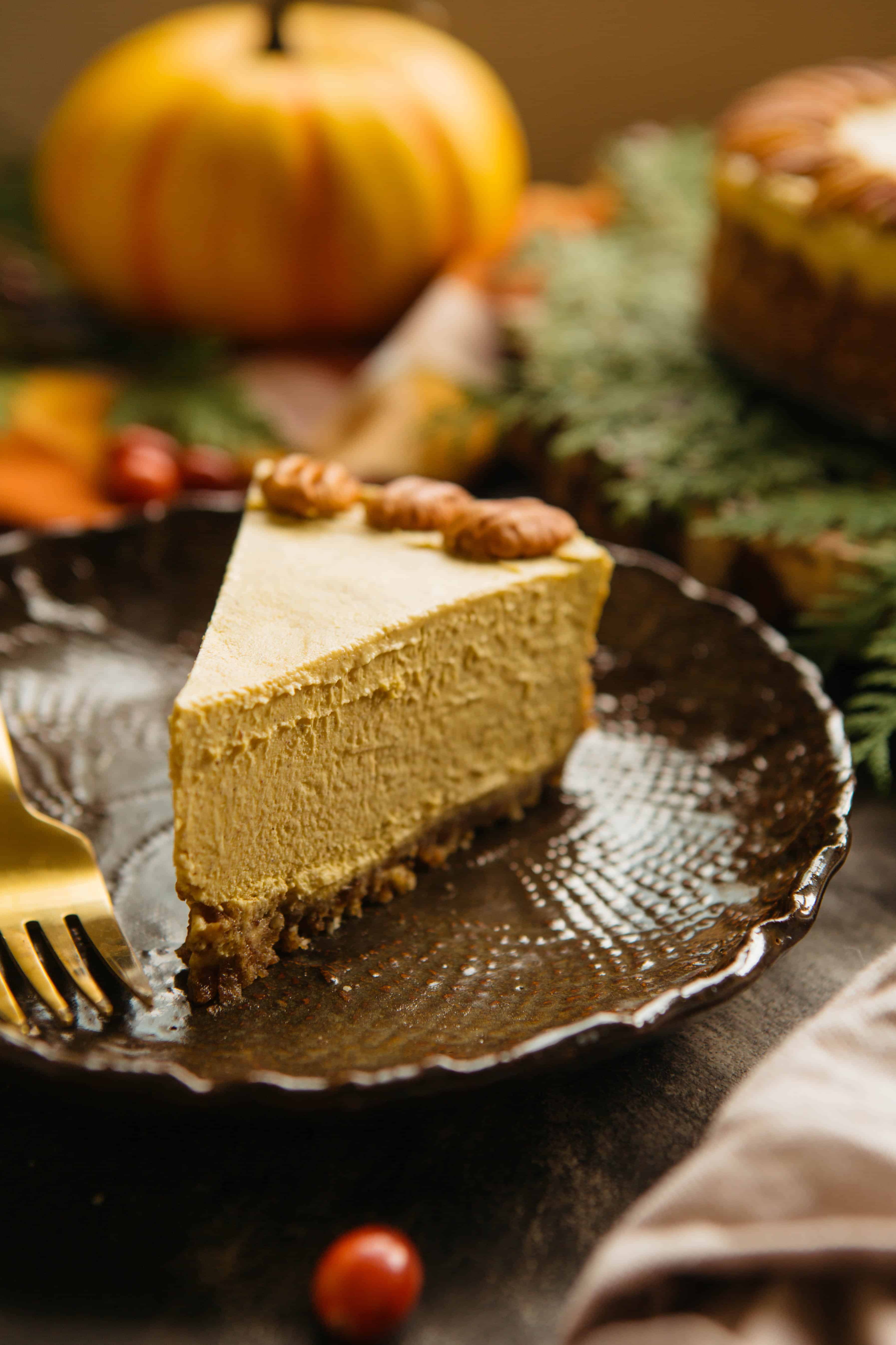 Triangle slice of vegan pumpkin cheesecake on a dessert plate.