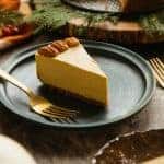 A blue dessert plate with a slice of vegan pumpkin cheesecake and fork.