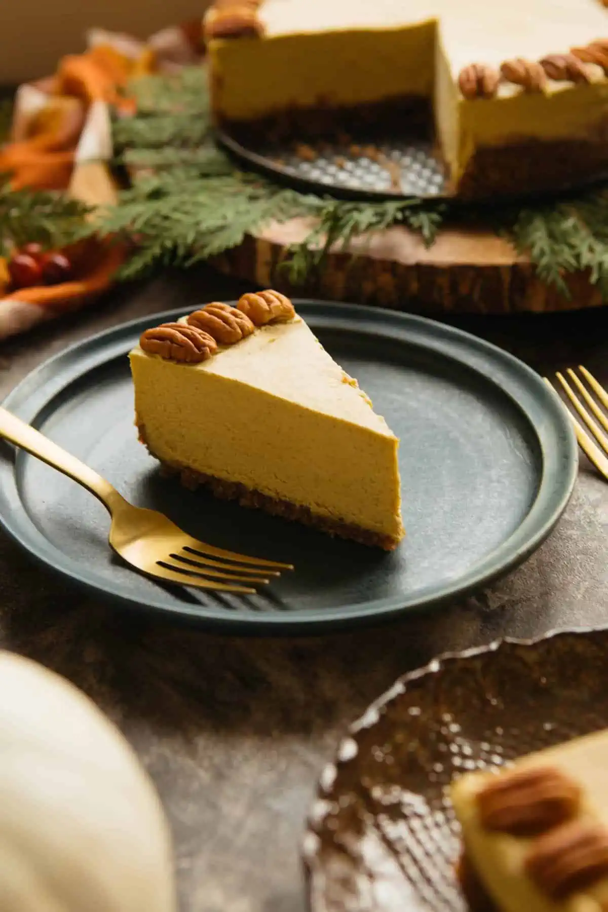 A blue dessert plate with a slice of vegan pumpkin cheesecake and fork.