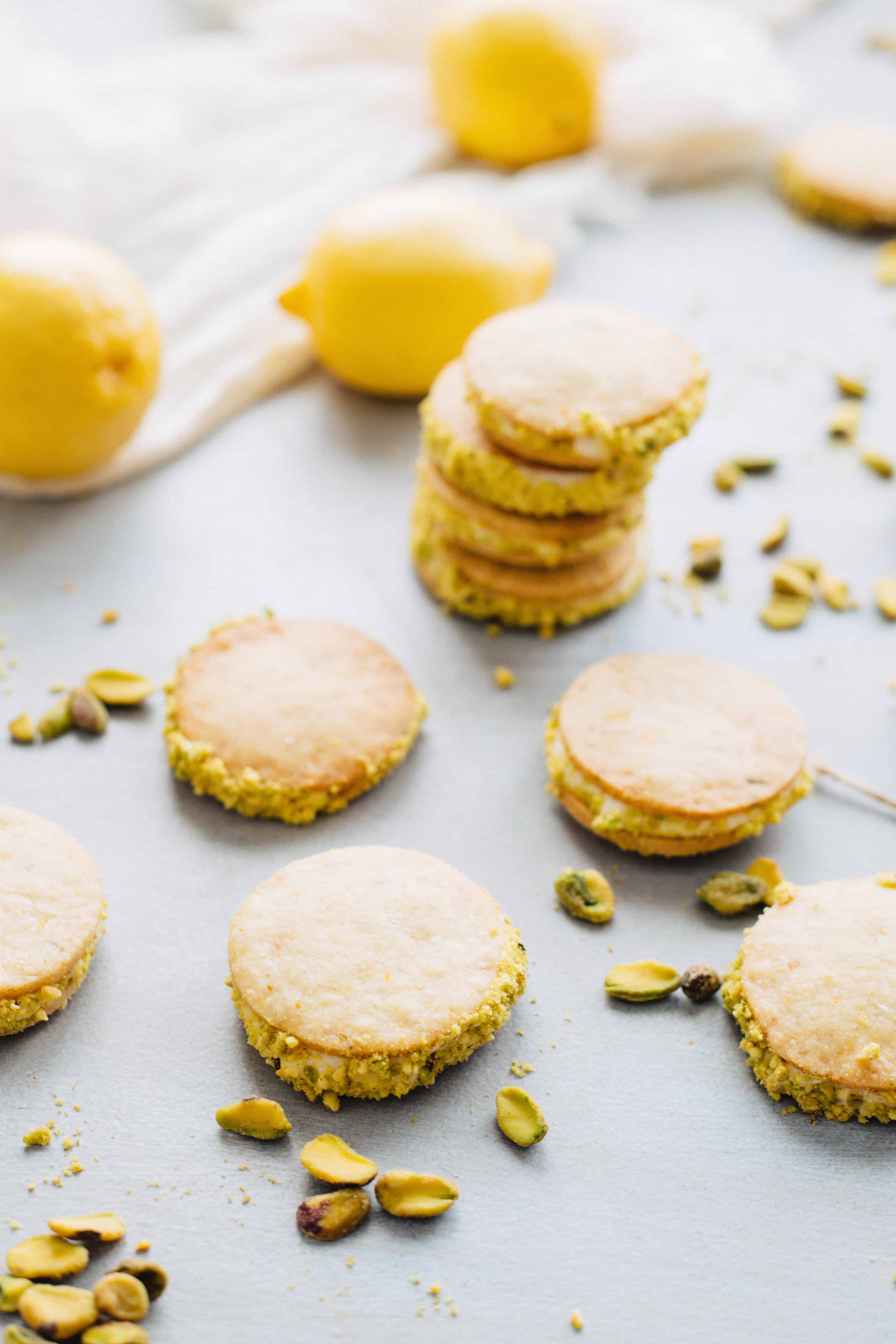 Lemon pistachio sandwich cookies assembled on a counter.