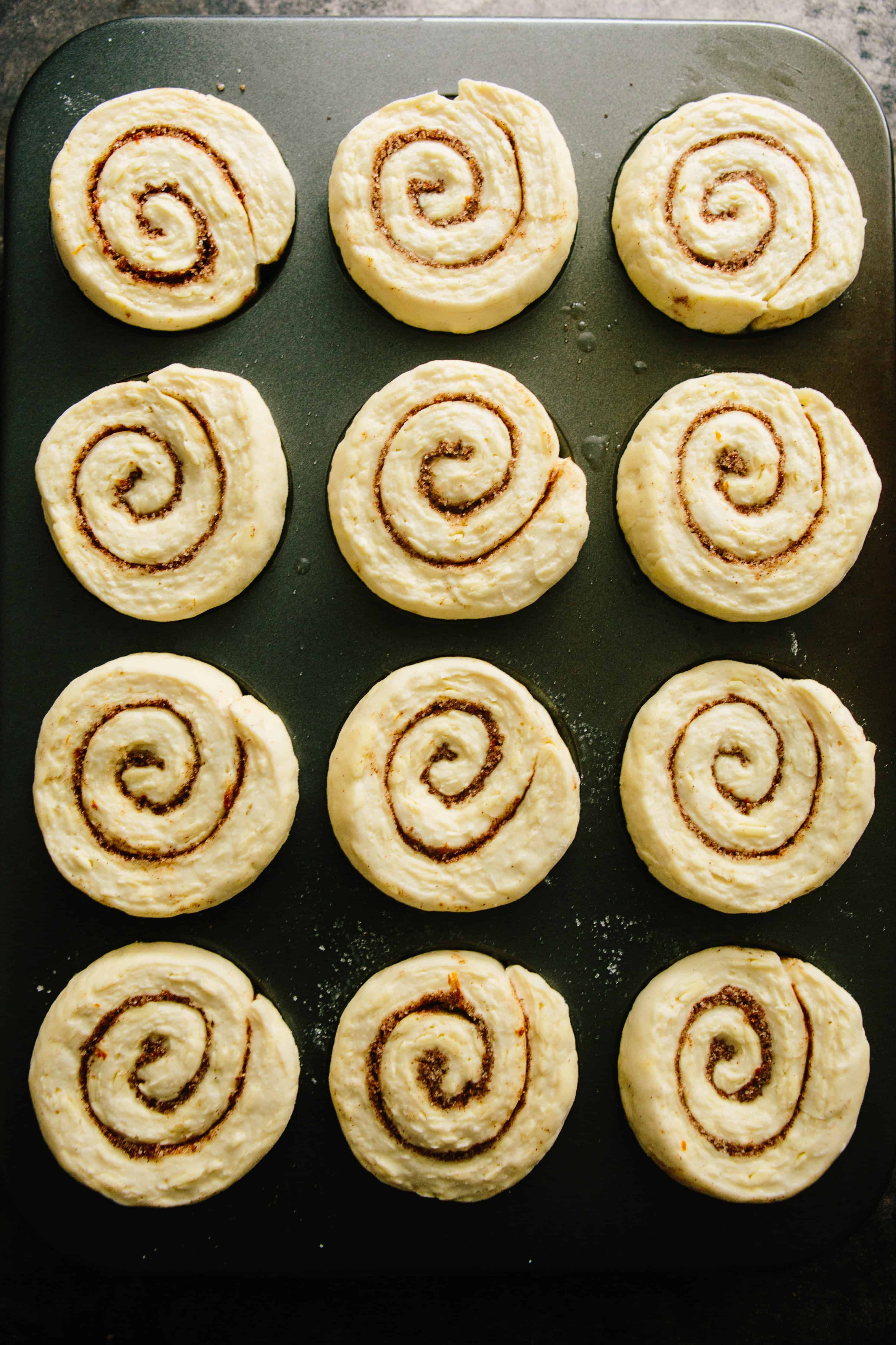 Top view of spiral croissant morning buns on a baking sheet waiting to be baked.