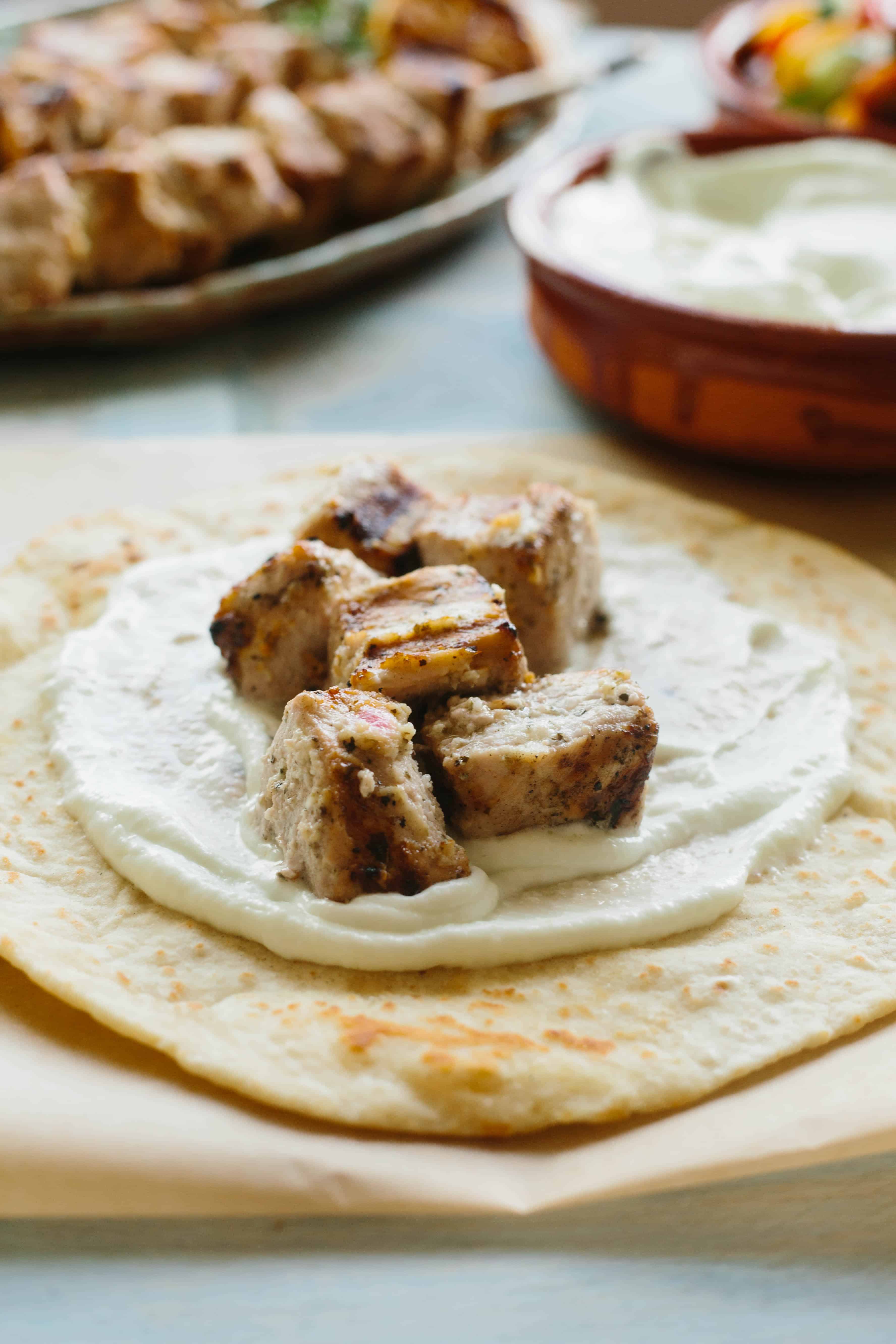 A pita spread with garlicky sauce and grilled pork cubes.