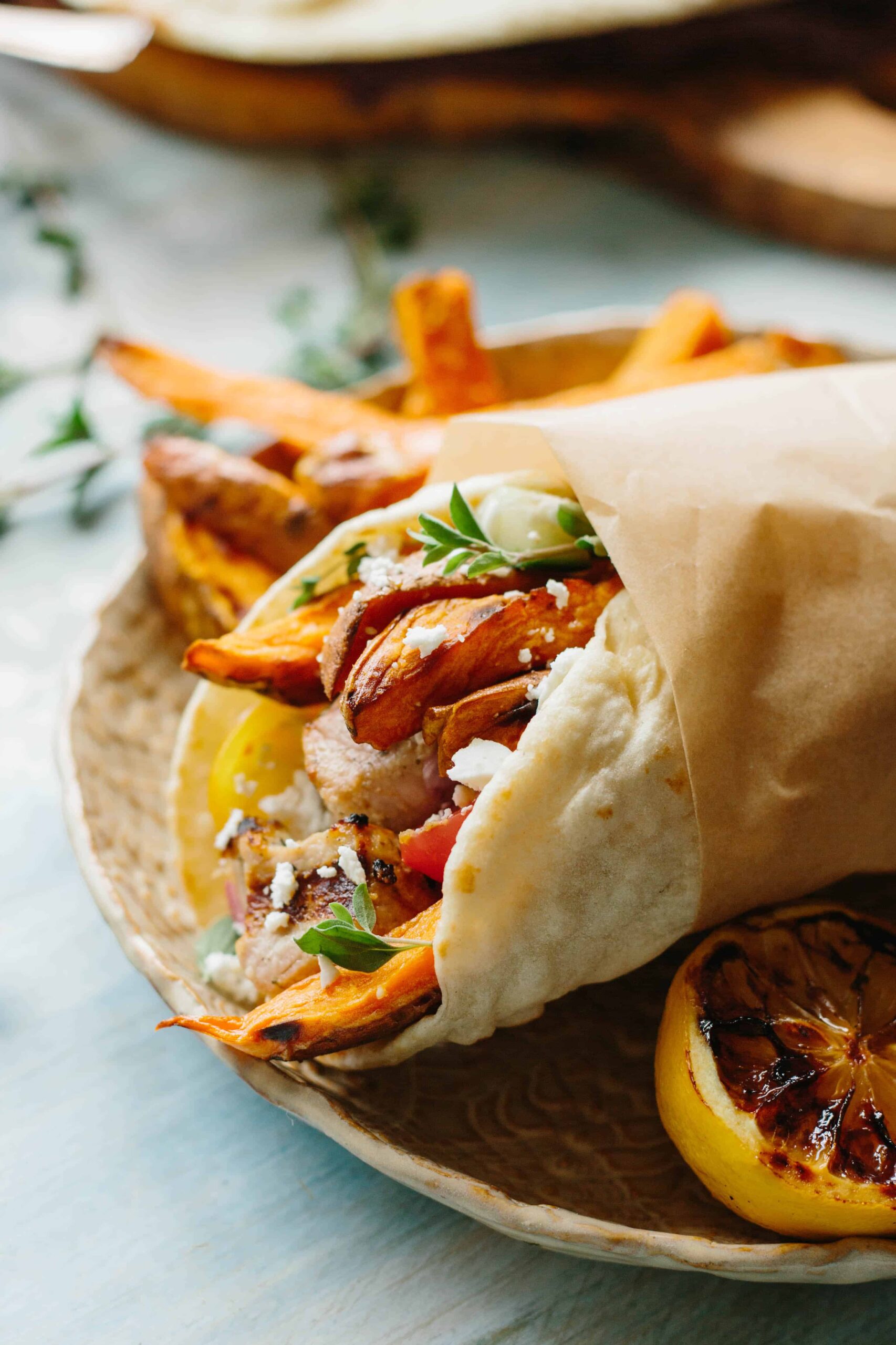 Pork kebab meat in a pita, wrapped in parchment paper.