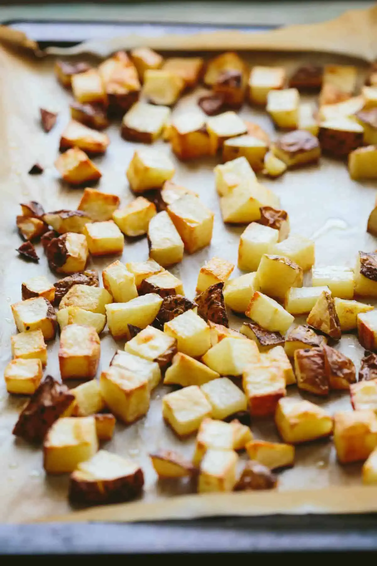 Small diced potatoes roasted on a baking sheet.