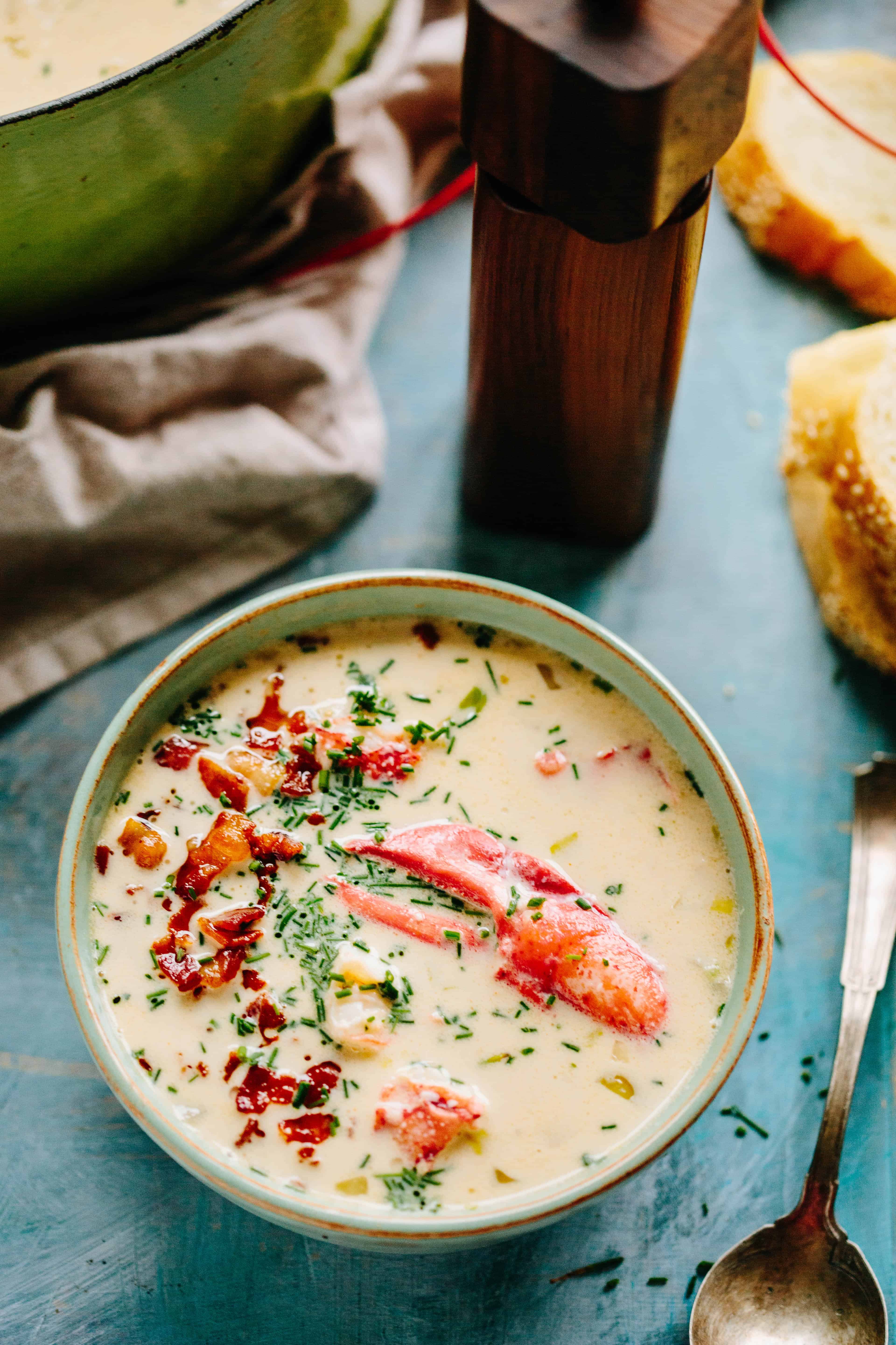 Vertical shot of creamy corn chowder with bacon and lobster.