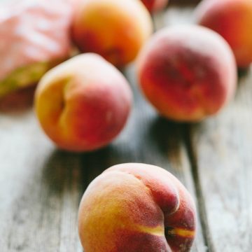 Beautiful whole peaches on a wooden table.