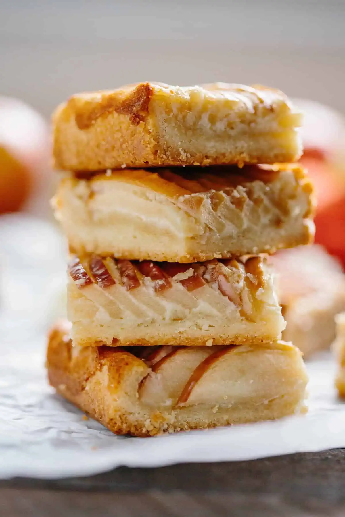 Close up side view of four apple almond shortbread slices stacked on top of one another.