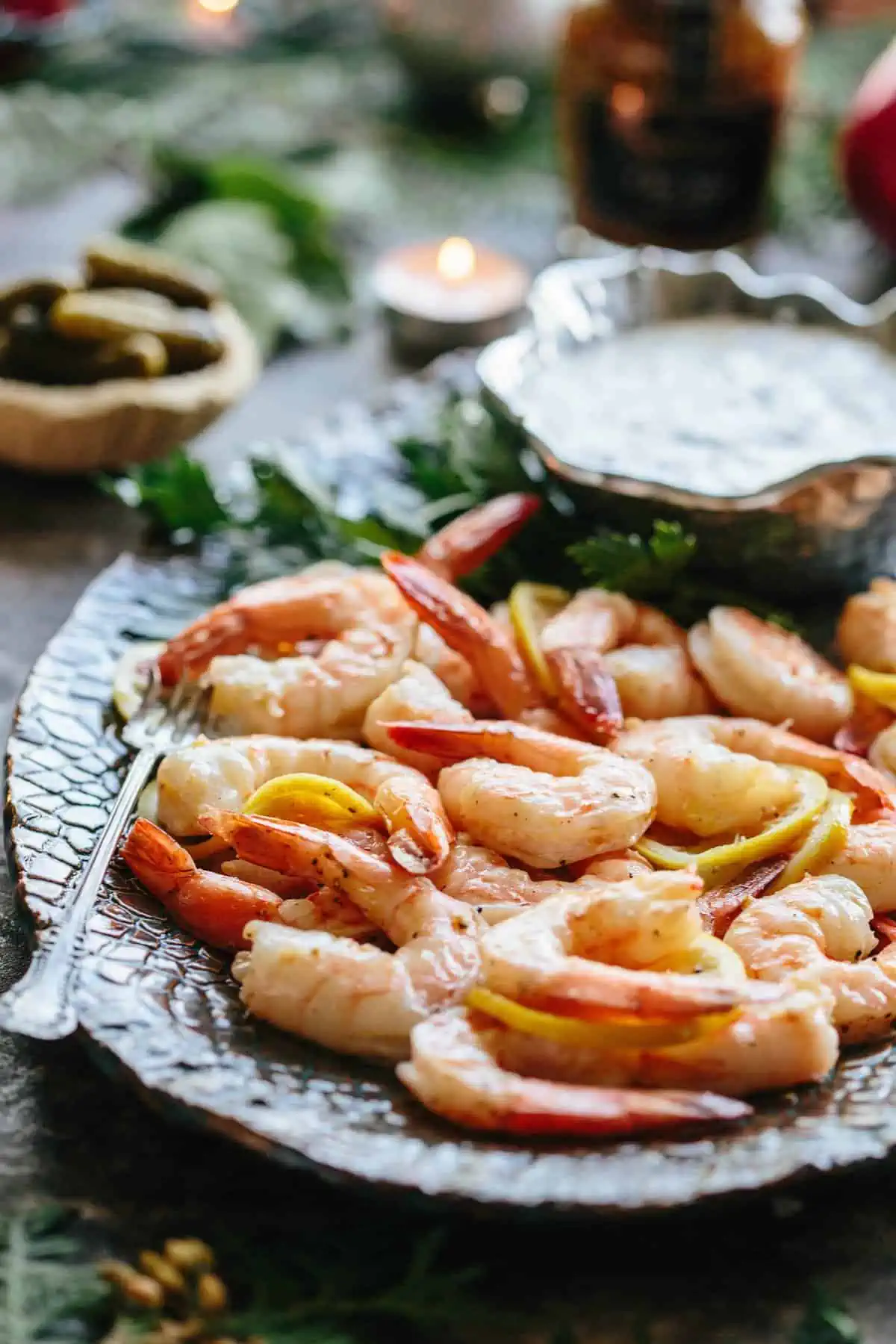 Close up of roasted shrimp and lemon on a serving platter.