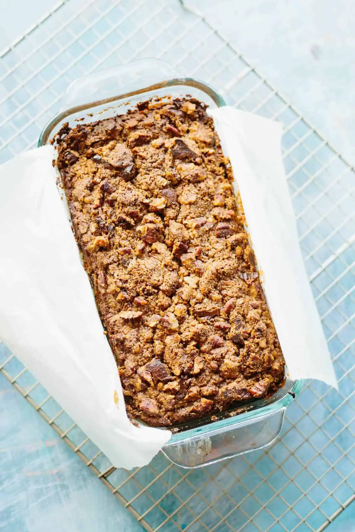 Top view of baked Paleo pecan streusel banana bread in a parchment-lined loaf pan.