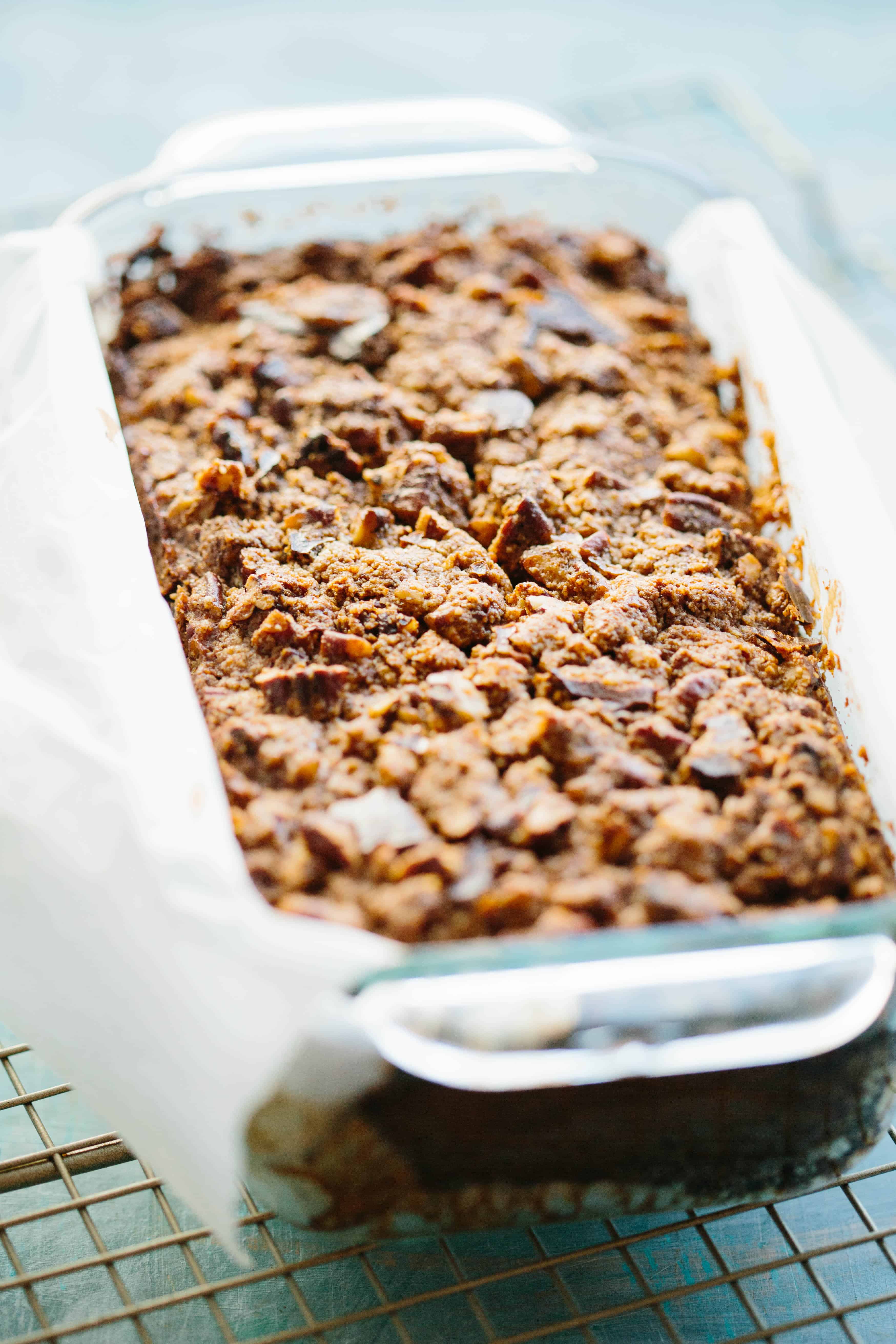 Closeup of the baked streusel topping on a loaf of Paleo banana bread in a glass loaf pan.