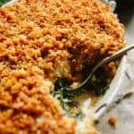 Close up of kale gratin with crunchy topping in a casserole dish.