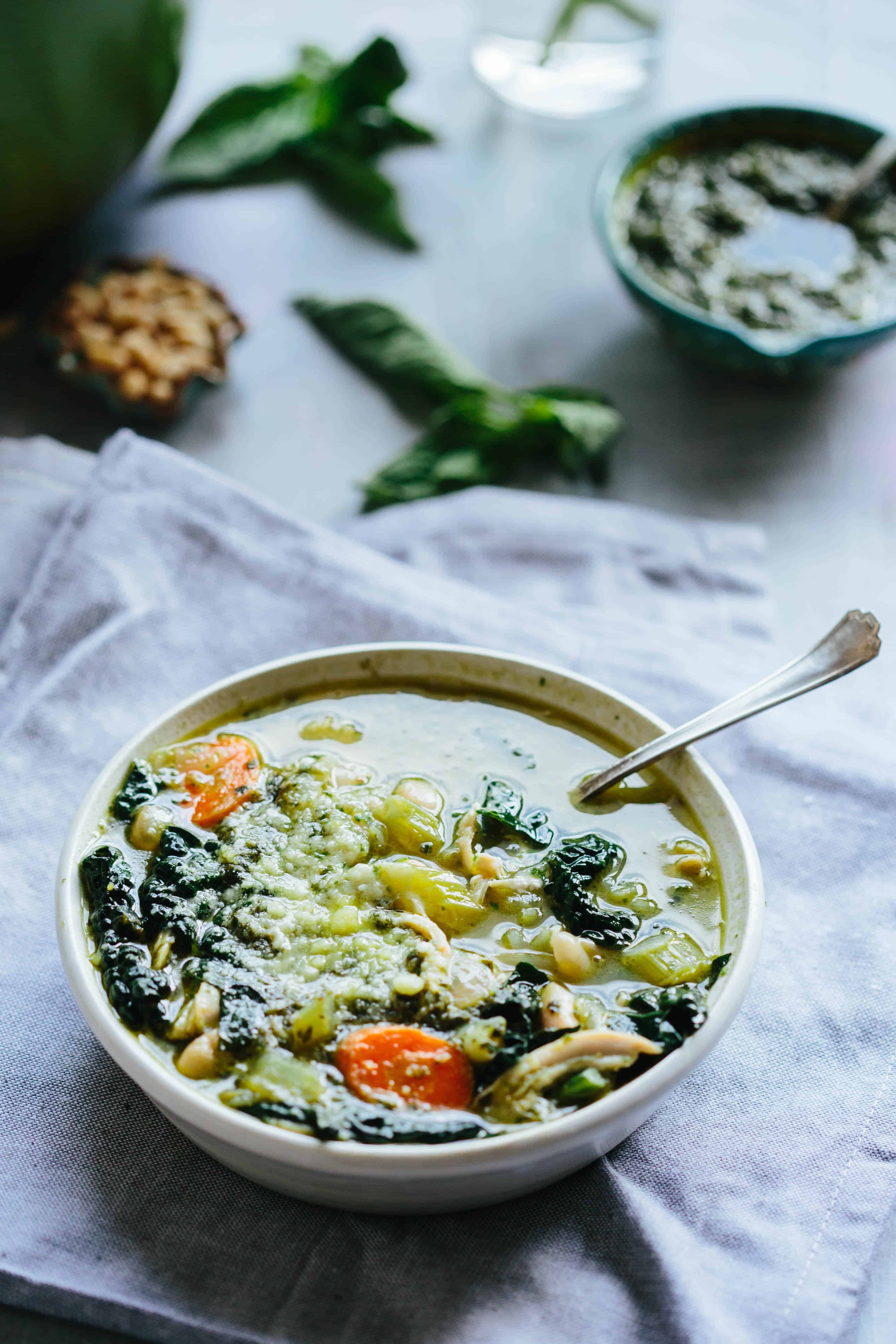 Angled shot of a bowl of chicken kale white bean soup that has carrots and celery.