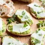 Close up of fava bean crostini topped with pecorino cheese.
