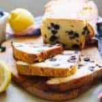 Lemon blueberry pound cake slices on a wood cutting board.