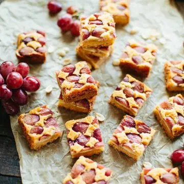 Sliced peanut butter grape bars on a sheet of parchment paper.