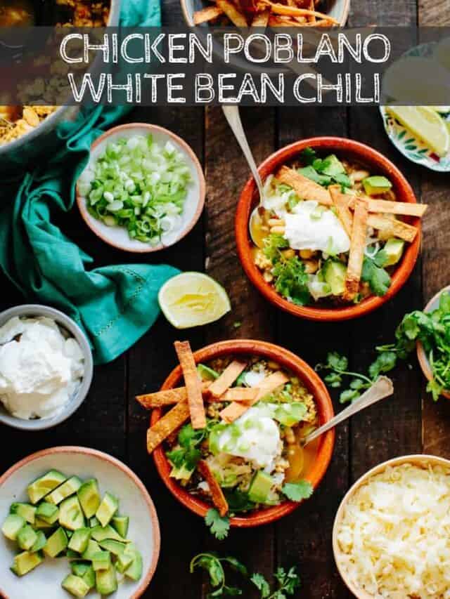 Vertical image of a table filled with bowls of poblano white bean chicken chili and all the toppings.