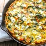 Top view of butternut squash and kale frittata in a cast iron skillet.