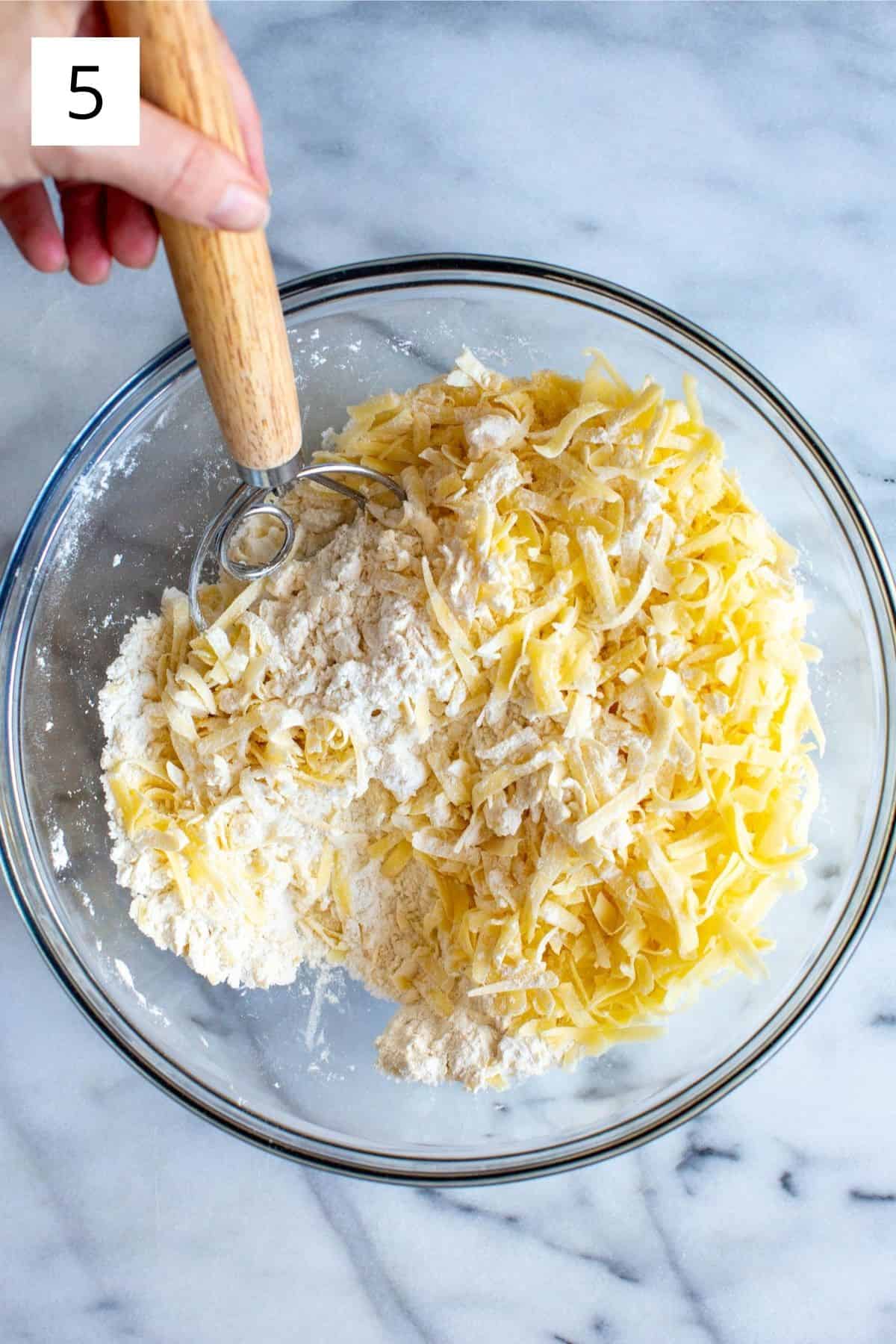 mixing grated cheddar into dry ingredients