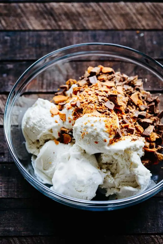 bowl of scooped vanilla ice cream with chopped candy on top