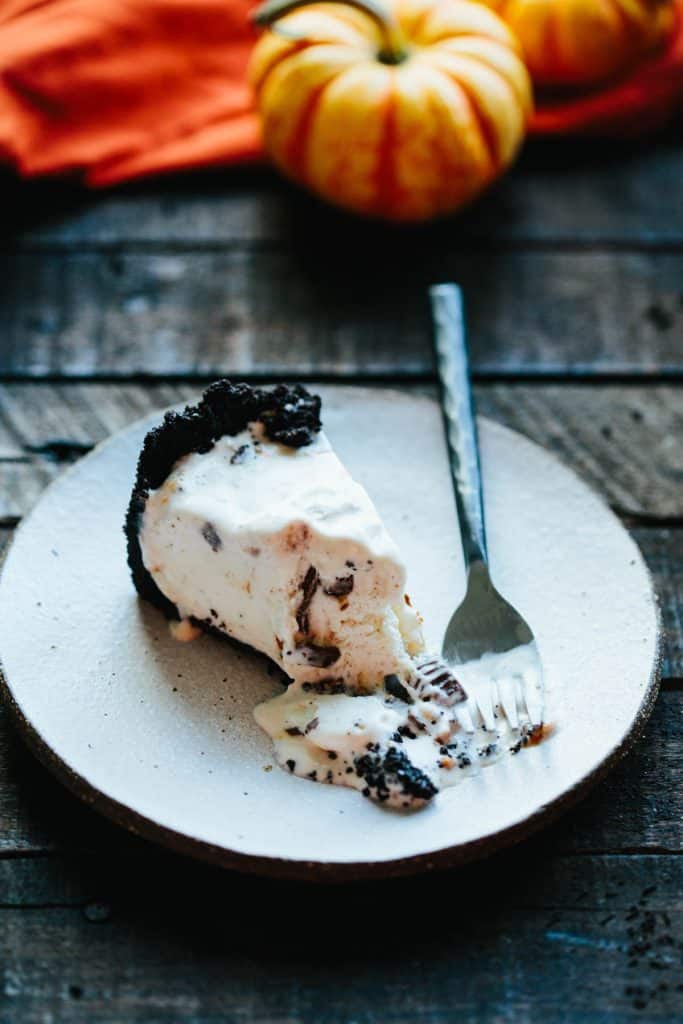 slice of ice cream pie on white plate with fork and bite taken out