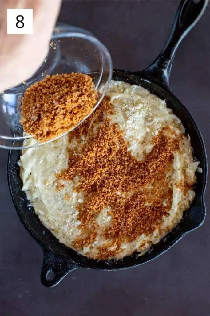 sprinting toasted panko over cast iron skillet with fennel and onions