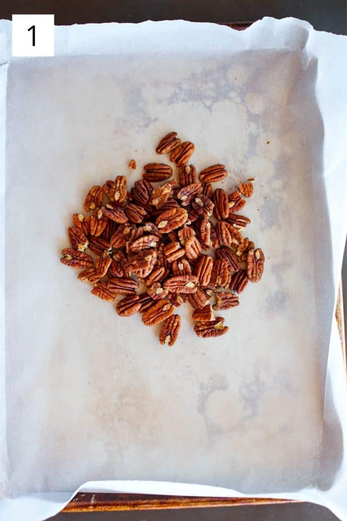 raw pecans on a parchment lined sheet pan