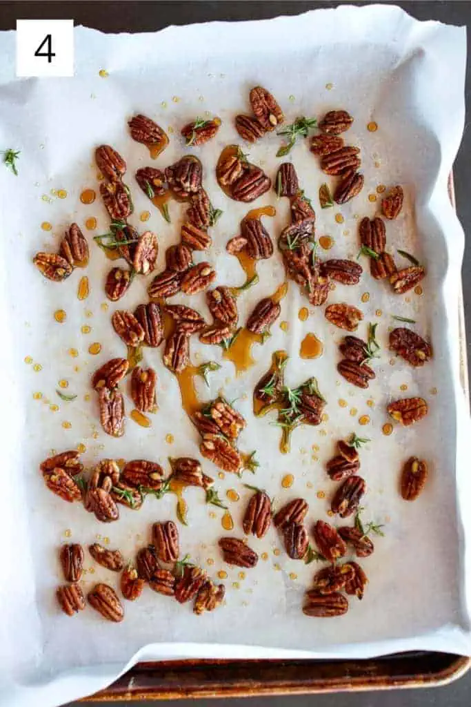 pecans, rosemary, sea salt and maple syrup spread out on a sheet pan