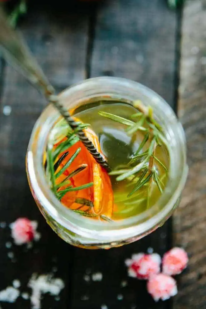 overhead close up of simple syrup with orange peel and rosemary