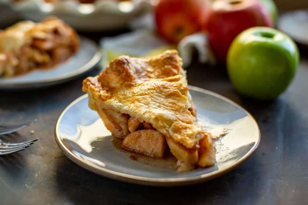 close up side view of a slice of apple pie