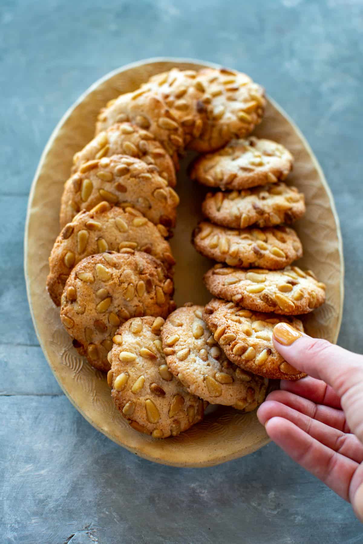 hand taking a cookie from a platter