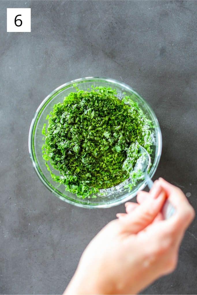 hand stirring Parsley Pistou in a clear glass bowl
