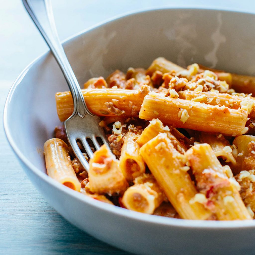 close up side view of rigatoni with sausage, mascarpone and walnuts